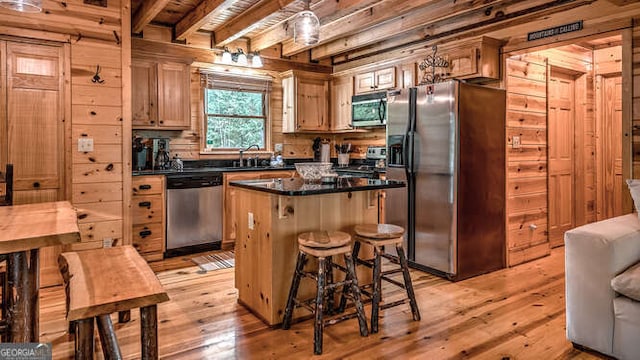 kitchen featuring stainless steel appliances, a center island, light wood-type flooring, and beamed ceiling