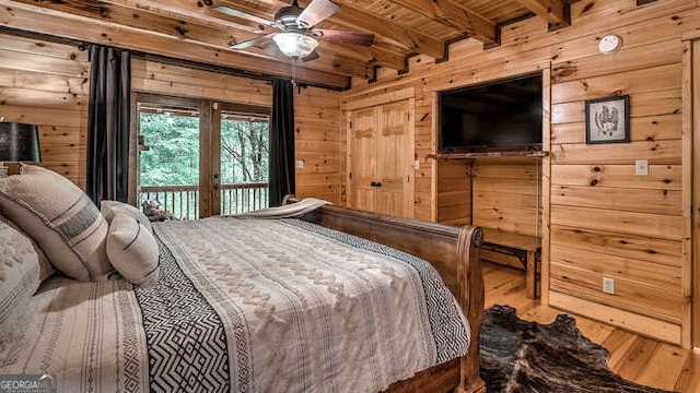 bedroom with wooden ceiling, access to outside, hardwood / wood-style flooring, wooden walls, and beamed ceiling