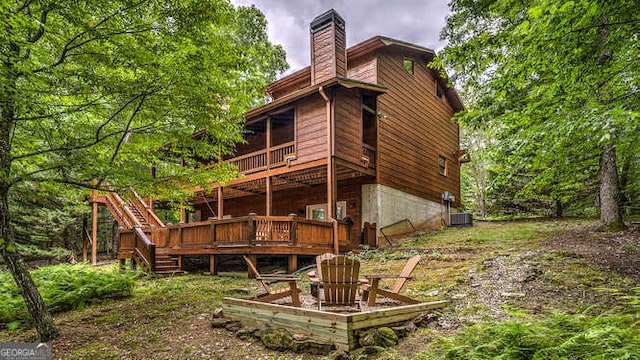 rear view of property featuring a wooden deck and central AC