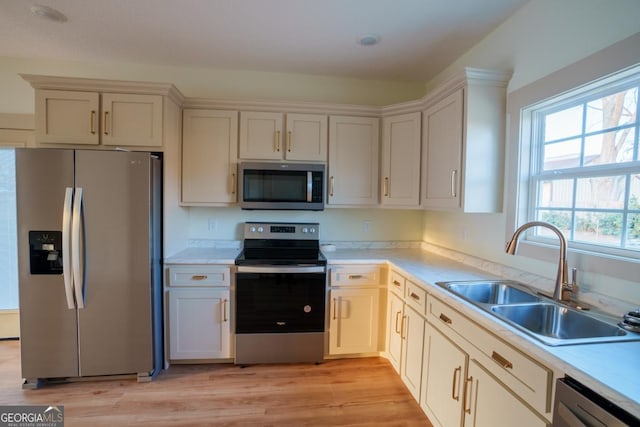 kitchen featuring stainless steel appliances, light hardwood / wood-style floors, and sink