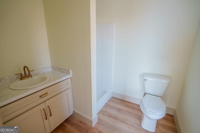 bathroom featuring vanity, toilet, and hardwood / wood-style floors