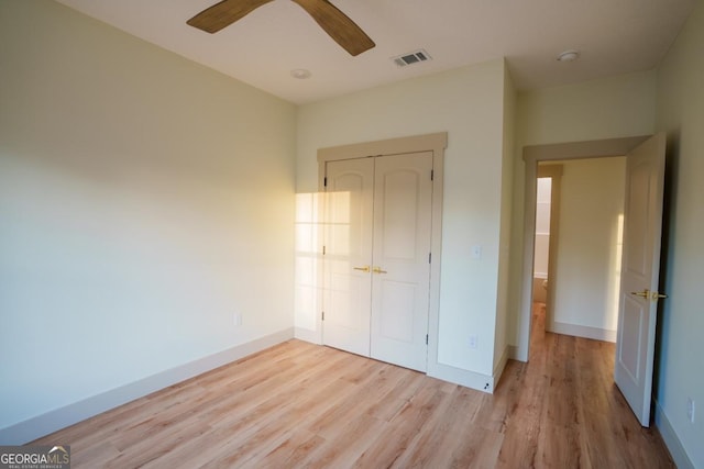 unfurnished bedroom with ceiling fan, light hardwood / wood-style floors, and a closet