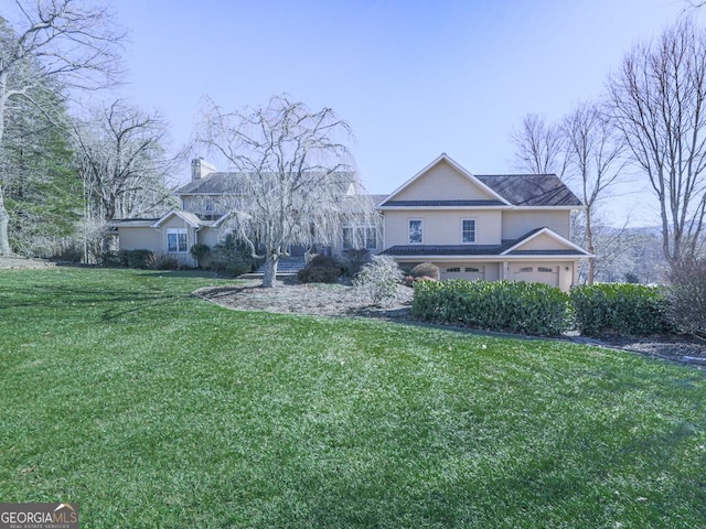 view of front of house featuring a front lawn and a garage