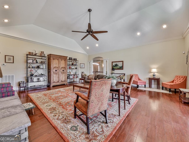 living room with ornamental molding, vaulted ceiling, ceiling fan, and wood-type flooring