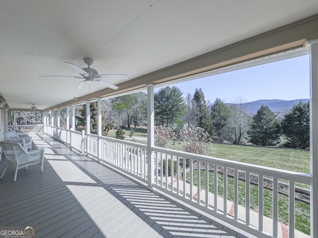 wooden terrace featuring a mountain view and ceiling fan