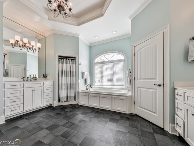 bathroom featuring a notable chandelier, a tray ceiling, ornamental molding, vanity, and a bathtub