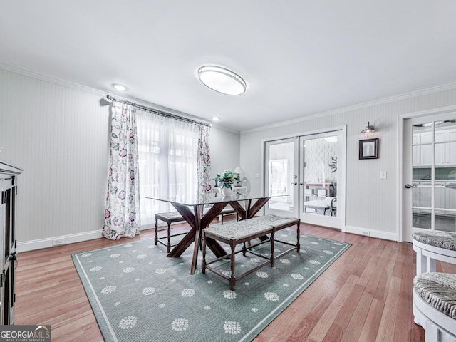 dining space with french doors, crown molding, and light hardwood / wood-style floors