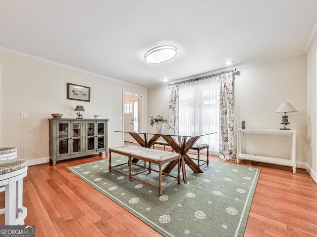 dining space with ornamental molding and hardwood / wood-style floors