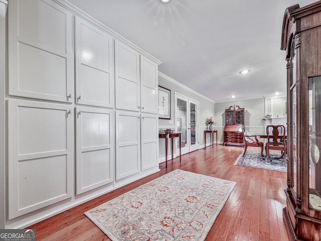 foyer entrance with light wood-type flooring and crown molding