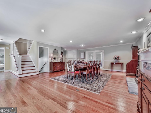 dining space with light hardwood / wood-style floors and crown molding