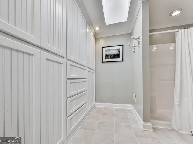 interior space with light tile patterned floors, crown molding, and a skylight