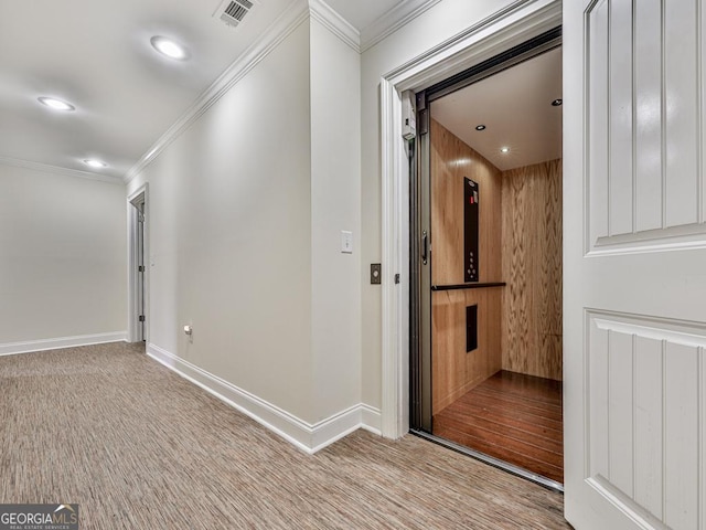 corridor with light colored carpet, elevator, and ornamental molding