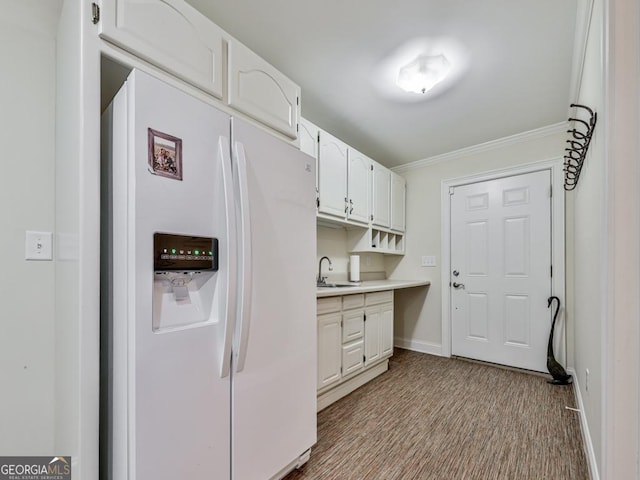 kitchen featuring white cabinetry, light wood-type flooring, white refrigerator with ice dispenser, sink, and crown molding