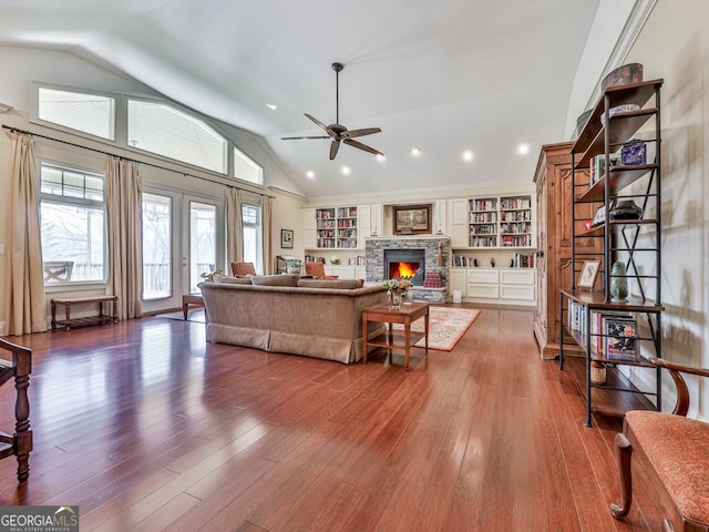 living room featuring a fireplace, high vaulted ceiling, dark hardwood / wood-style floors, and french doors