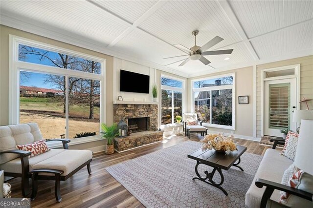 living room featuring hardwood / wood-style floors, coffered ceiling, a wealth of natural light, and a fireplace