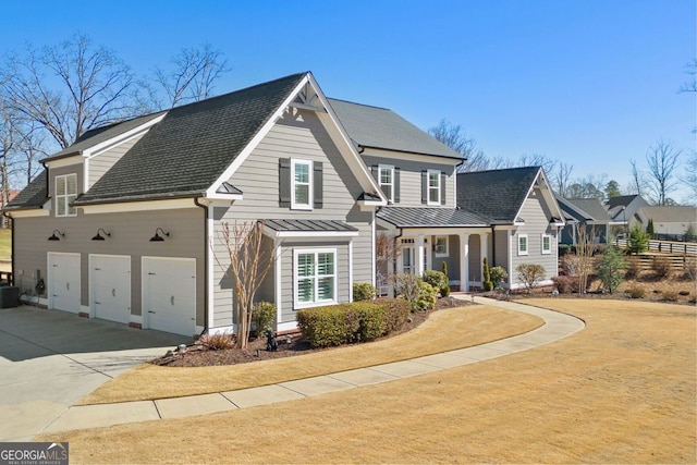 view of property with a garage, a front lawn, and central AC unit