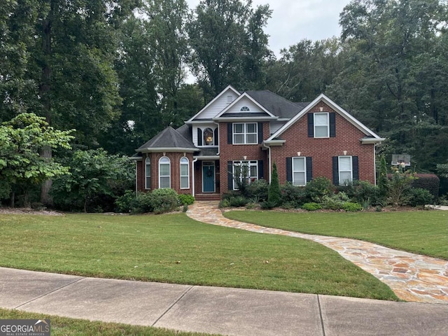 view of front facade with a front lawn and brick siding