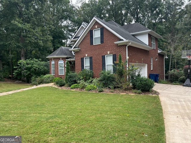 view of front of property with an attached garage, brick siding, driveway, and a front lawn