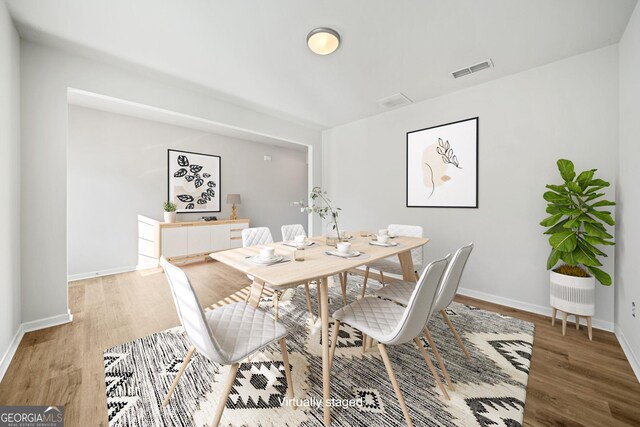 dining space with visible vents, baseboards, and wood finished floors