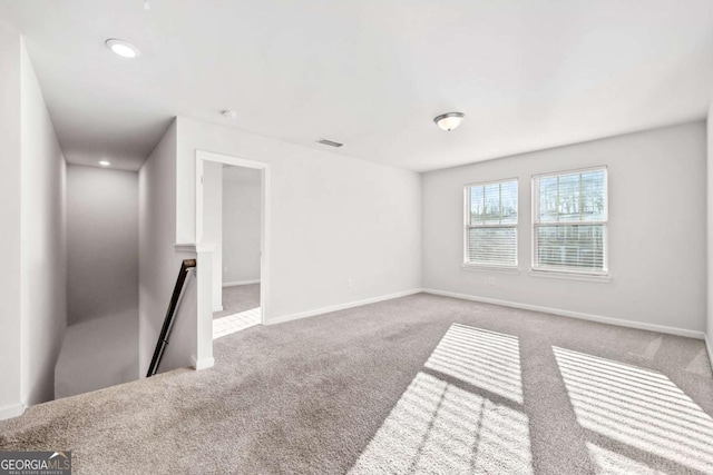 unfurnished room featuring carpet, visible vents, baseboards, and recessed lighting