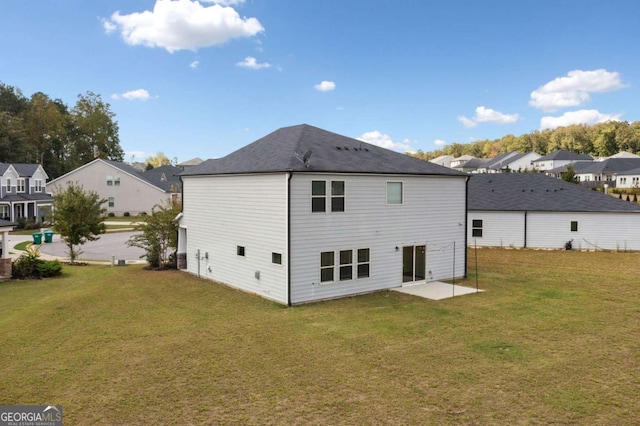 rear view of house featuring a residential view and a yard