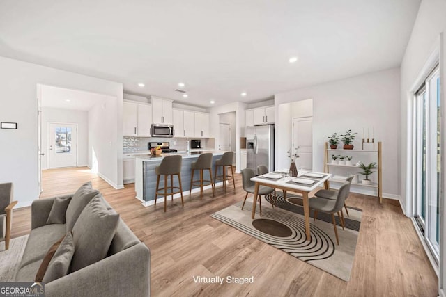 interior space featuring baseboards, recessed lighting, and light wood-style floors