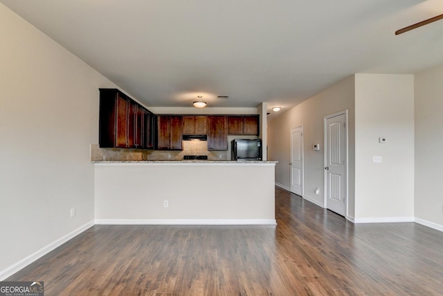 kitchen with refrigerator, backsplash, ceiling fan, dark wood-type flooring, and kitchen peninsula