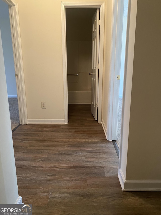 hall with baseboards and dark wood finished floors