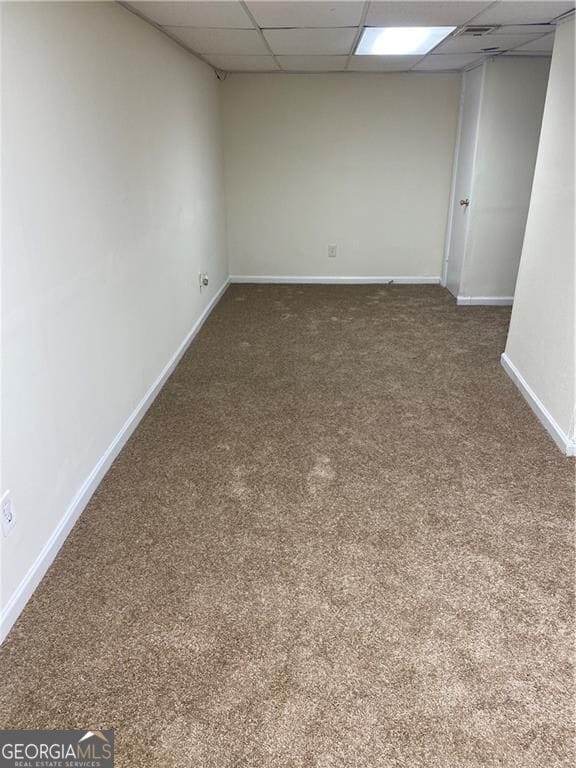 spare room featuring baseboards and a paneled ceiling