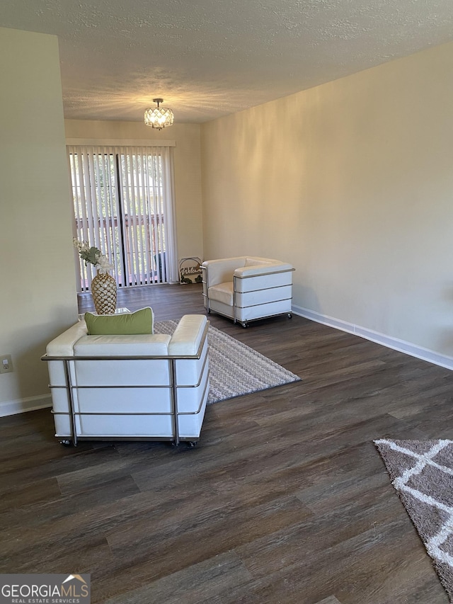 unfurnished room with a textured ceiling, dark wood-type flooring, and baseboards