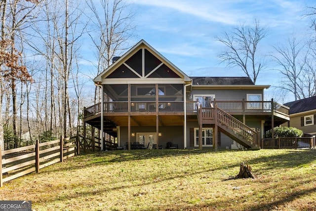 back of property with a lawn, a sunroom, and a deck