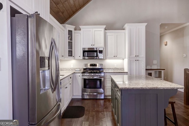 kitchen featuring stainless steel appliances, dark hardwood / wood-style flooring, light stone countertops, and white cabinets