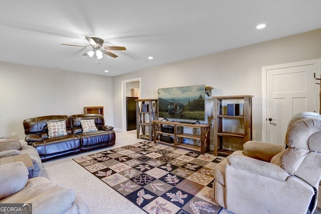 carpeted living room with ceiling fan