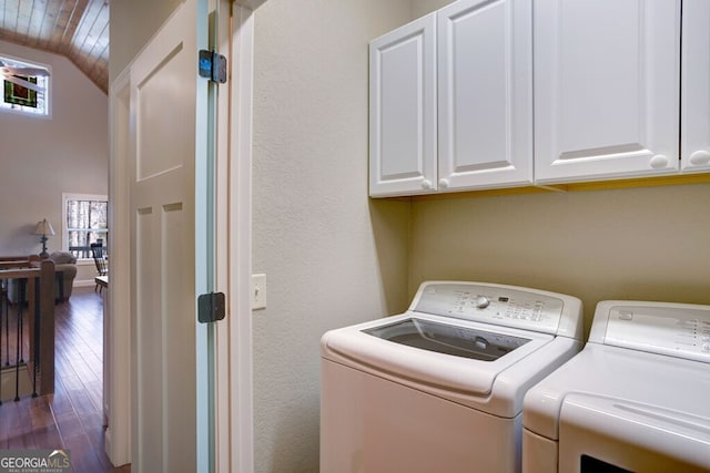 washroom featuring cabinets, dark wood-type flooring, and washer and clothes dryer