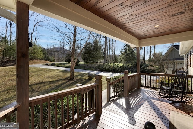 wooden deck featuring a lawn and a porch