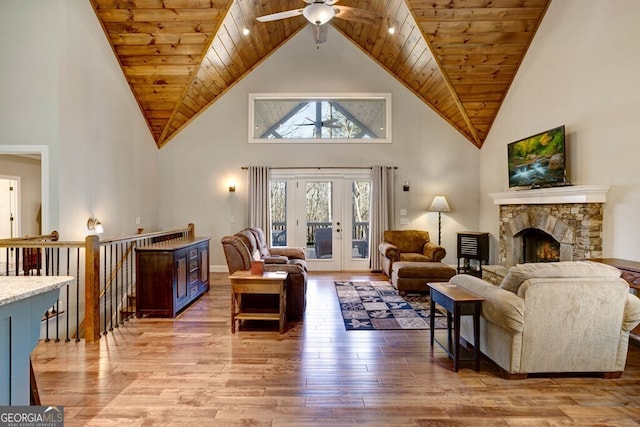 living room featuring wood ceiling, high vaulted ceiling, a fireplace, and hardwood / wood-style floors