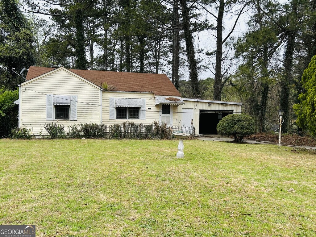 view of front of house with a shingled roof and a front yard