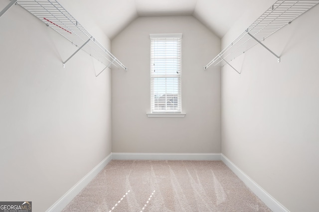 walk in closet with carpet and vaulted ceiling