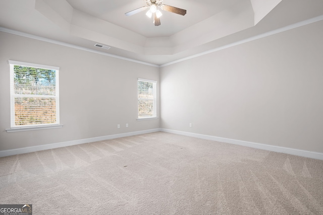 unfurnished room with baseboards, a tray ceiling, a ceiling fan, and light colored carpet