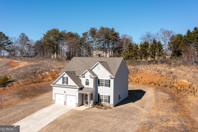 traditional-style home featuring a garage, concrete driveway, and roof with shingles