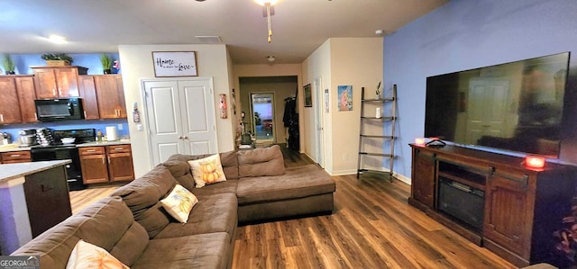 living room with dark hardwood / wood-style floors and ceiling fan