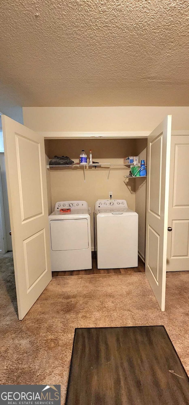 laundry area featuring separate washer and dryer, a textured ceiling, and carpet