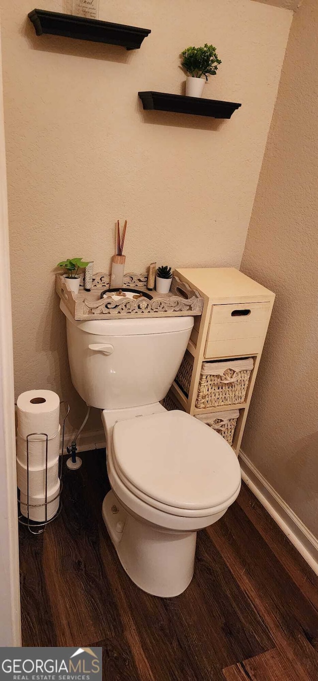 bathroom featuring hardwood / wood-style flooring and toilet