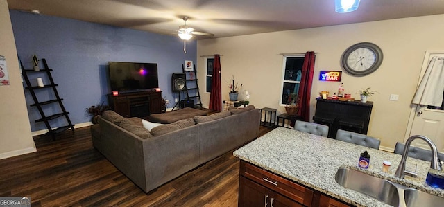 living room with sink, dark wood-type flooring, and ceiling fan