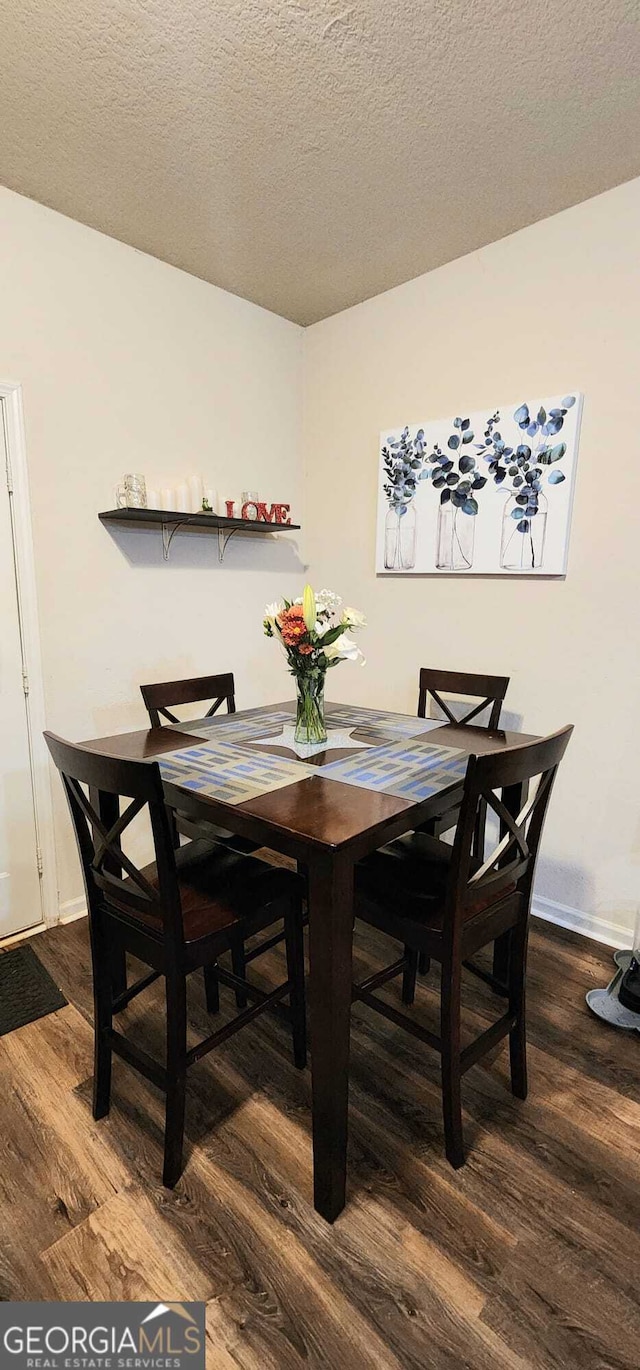 dining room with hardwood / wood-style floors and a textured ceiling