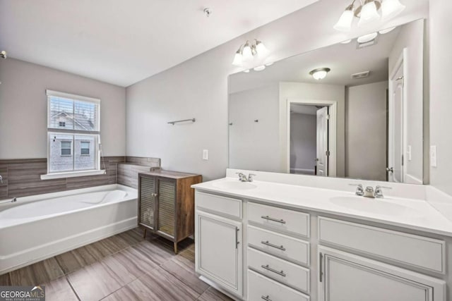 bathroom with vanity and a tub to relax in