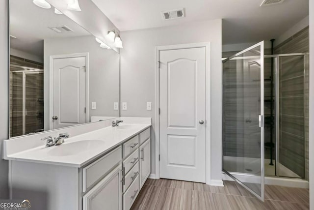 bathroom with vanity and a shower with shower door