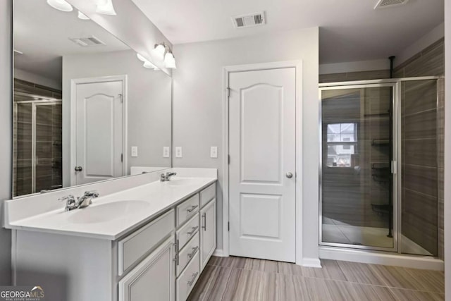 bathroom with vanity and a shower with shower door