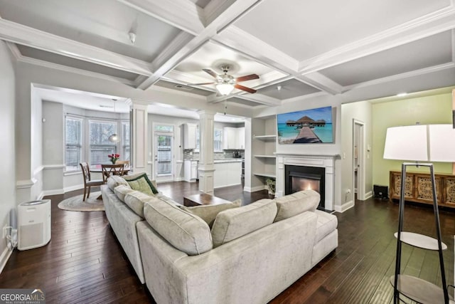 living room featuring dark hardwood / wood-style flooring, coffered ceiling, and decorative columns