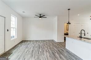 interior space with hanging light fixtures, hardwood / wood-style flooring, sink, and ceiling fan